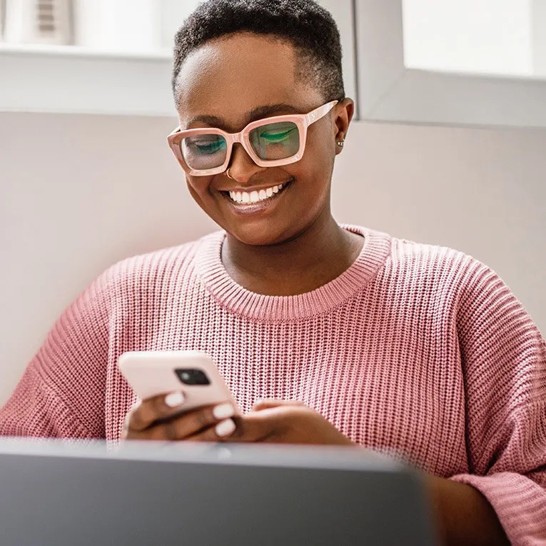 A person smiling while looking at a mobile phone